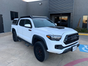 Front passenger view of white Toyota Tacoma with Economy Roof Rack - Cali Raised LED